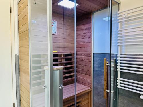 a sauna with a glass door in a room at Ferienwohnung Sonnendeck Parkvillen Carlota und Candela Baabe in Baabe