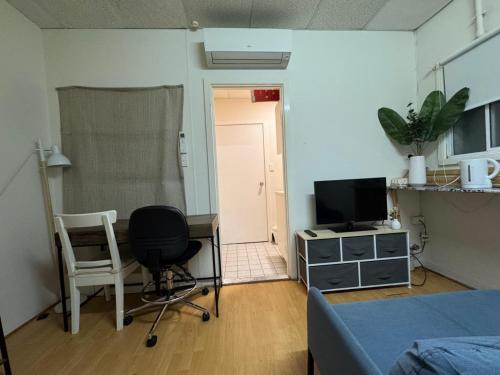 a room with a bed and a desk and a television at Studio 7 - Wright Lodge in Adelaide