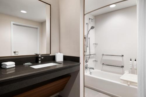 a bathroom with a sink and a tub and a mirror at Fairfield by Marriott Inn & Suites Bethlehem PA in Bethlehem