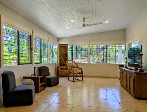 a large living room with windows and chairs in it at Un Oasis Natural a Minutos de Asunción in Luque