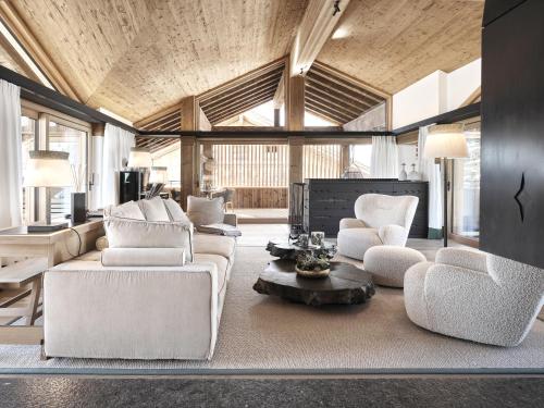 a living room with couches and chairs and a table at Lech Lodge - LEGENDARY in Lech am Arlberg