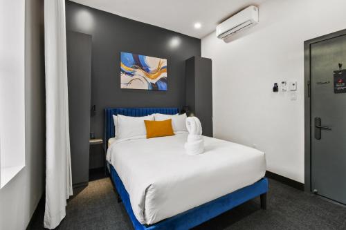 a bedroom with a large bed with a blue headboard at Lift Hotel in Montréal
