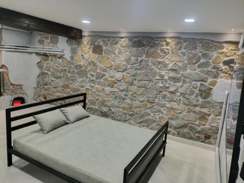 a bed in a room with a stone wall at 46 Loft apartment with king-size bed in Chernihiv