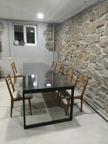a table and chairs in a room with a stone wall at 46 Loft apartment with king-size bed in Chernihiv