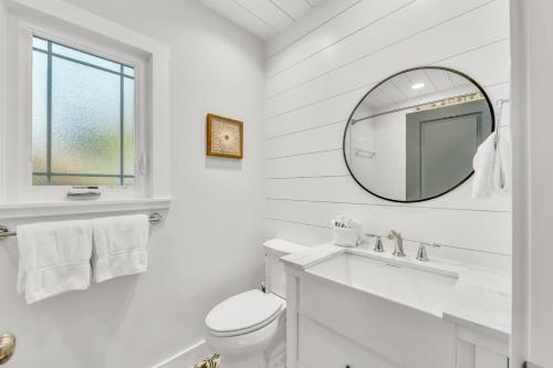 a white bathroom with a mirror and a sink at Sabai Sabai in Bradenton