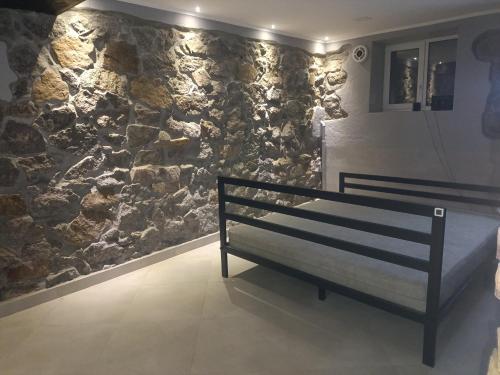 a bench in a room with a stone wall at 46 Loft apartment with king-size bed in Chernihiv