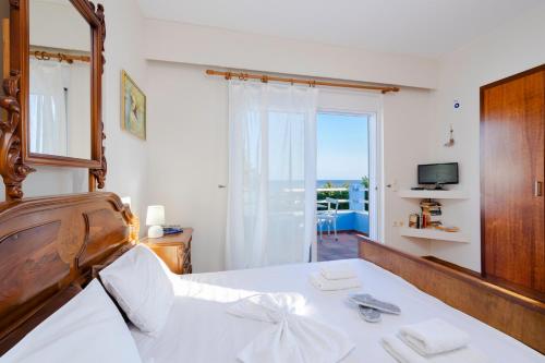 a bedroom with a bed with a view of the ocean at Beachfront Studio Socrates in Gennadi