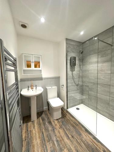 a bathroom with a toilet and a sink and a shower at Large City Centre Apartment in Perth