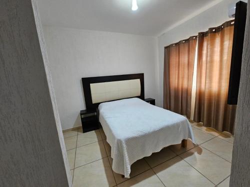 a bedroom with a white bed and a window at El hogar que deseas para vacacionar!!!! in Cancún