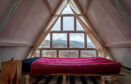 a bed in a room with a large window at Illamama in La Paz