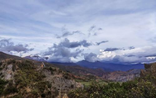 a view of a mountain with a house on a hill at Illamama in La Paz