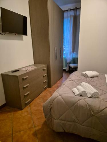 a bedroom with a bed and a dresser and a television at Locanda Rocchetta-Premilcuore in Premilcuore