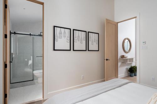 a white bedroom with a shower and a bed at Chalet Eau, style Lake house à Tremblant in Lac-Superieur