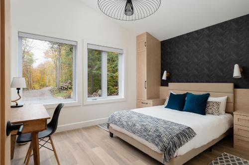 a bedroom with a bed and a desk and a window at Chalet Eau, style Lake house à Tremblant in Lac-Superieur