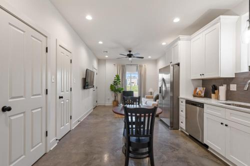 a kitchen with white cabinets and a table and chairs at Bourbon House King Bed Luxury Amenities Fast WiFi in Lafayette