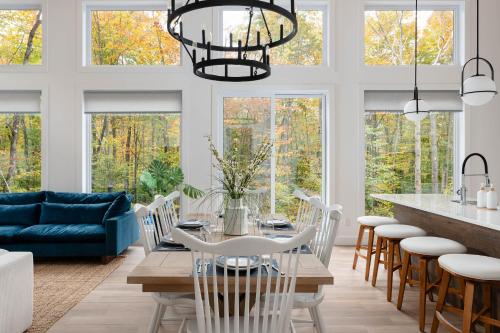 a dining room and living room with a table and chairs at Chalet Eau, style Lake house à Tremblant in Lac-Superieur