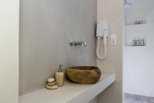 a bathroom with a stone sink on a counter at Apartments Enosis, Alia in Agios Prokopios