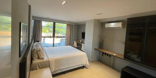 Un dormitorio con una cama y una ventana grande. en Flat completo no Infinity at the sea, en João Pessoa