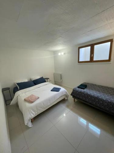 une chambre blanche avec un grand lit et une fenêtre dans l'établissement Maison familiale proche Paris, à Domont