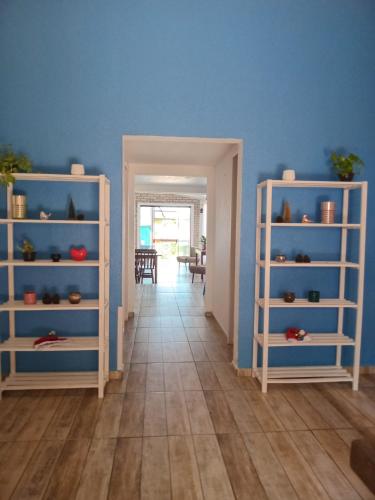 a hallway with blue walls and white shelves at Vila Penelope Guest House in Balneário Camboriú