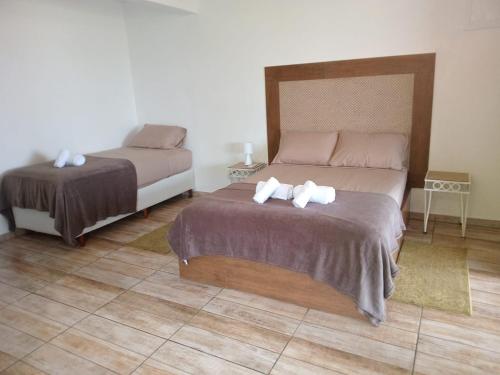 a bedroom with two beds with towels on them at Vila Penelope Guest House in Balneário Camboriú