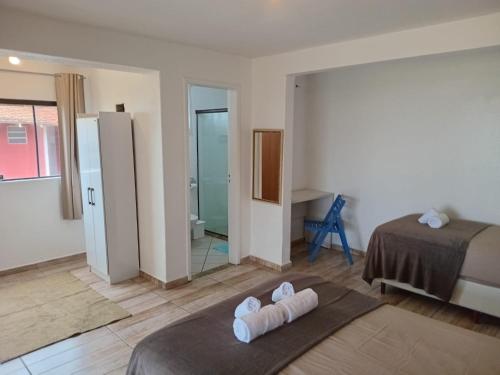 a bedroom with a bed with two towels on it at Vila Penelope Guest House in Balneário Camboriú