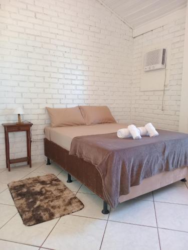 a bed in a room with two towels on it at Vila Penelope Guest House in Balneário Camboriú