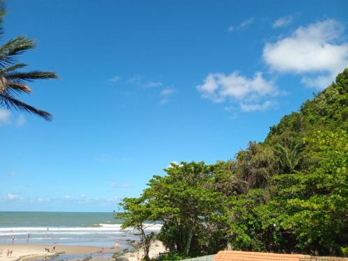 a beach with people walking on the sand and the ocean at Vila Penelope Guest House in Balneário Camboriú
