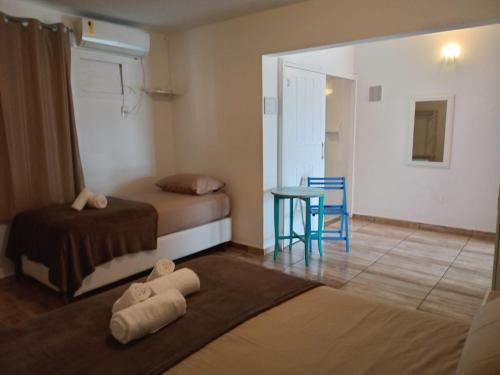 a small room with two beds and a table at Vila Penelope Guest House in Balneário Camboriú