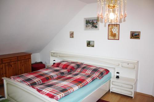 a bed with a plaid pillow on top of it at Apartment Na Rozcestí in Lipno nad Vltavou