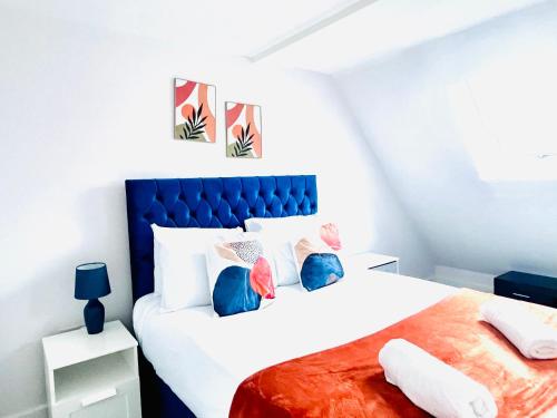 a bedroom with a large white bed with colorful pillows at Stunning Five Bedroom Holiday Home in Chartham Canterbury with Hot Tub in Chartham