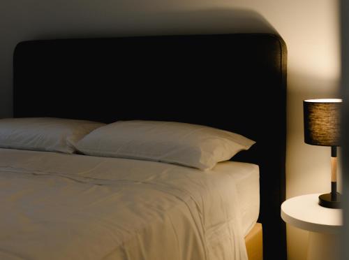 a bedroom with a bed with a black headboard and a lamp at Apartment 2 Hospital Road Wellington in Wellington