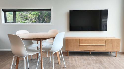 a dining room with a table and chairs and a tv at Apartment 2 Hospital Road Wellington in Wellington