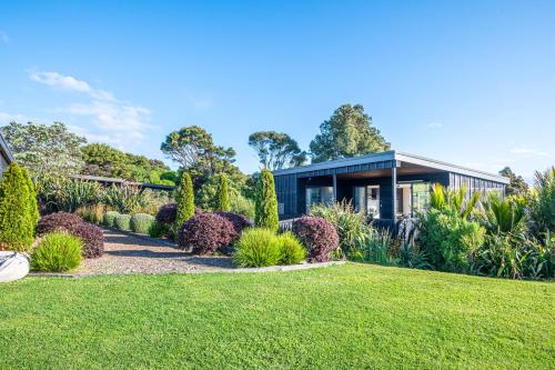 a house with a garden in front of it at Villas Waiheke in Onetangi
