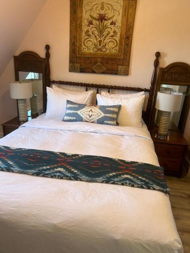 a bedroom with a bed with pillows and a painting on the wall at Arrowhead Lake Inn in Lake Arrowhead