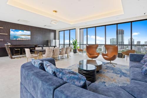 a living room with a blue couch and chairs at Stay Luxe Southport - Hosted by Coastal Letting Co. in Gold Coast