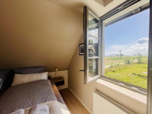 Ferienhaus Huus Waterkant 18 Feriendorf Klein Stresow Rügen by ruyastay في بوتبوس: غرفة نوم صغيرة بها سرير ونافذة