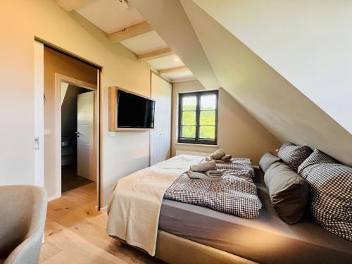 Ferienhaus Mein Ankerplatz 17 Feriendorf Klein Stresow Rügen by ruyastay في بوتبوس: غرفة نوم بها سرير وتلفزيون على الحائط
