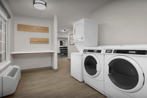 a white laundry room with a washer and dryer at Staybridge Suites Raleigh-Durham Airport-Morrisville by IHG in Morrisville