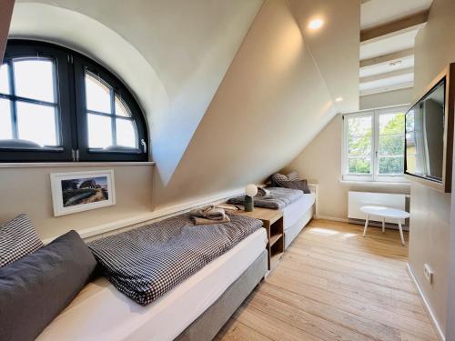 een woonkamer met twee bedden en een tv bij Ferienhaus Reetblick 23 Feriendorf Klein Stresow Rügen by ruyastay in Putbus