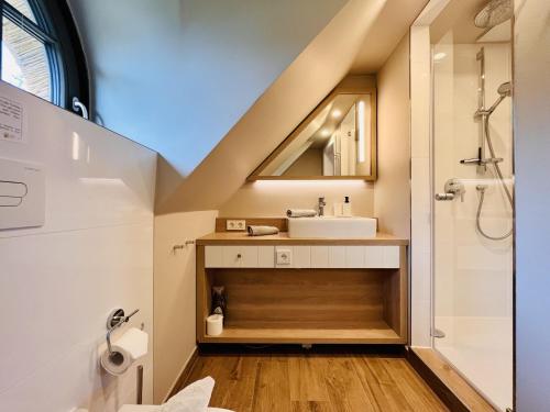 een badkamer met een wastafel en een douche bij Ferienhaus Reetblick 23 Feriendorf Klein Stresow Rügen by ruyastay in Putbus