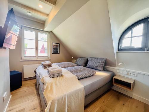 Ferienhaus Boddenlust 24 Feriendorf Klein Stresow Rügen by ruyastay في بوتبوس: غرفة نوم صغيرة بها سرير ونافذتين