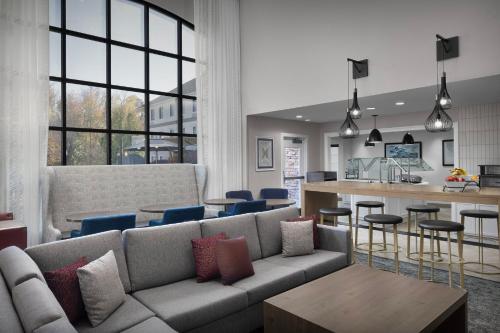 a living room with a couch and a kitchen at Staybridge Suites Raleigh-Durham Airport-Morrisville by IHG in Morrisville