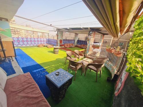 a patio with a green yard with chairs and a table at Castle Hotel in Cairo