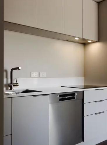 a kitchen with white cabinets and a sink at Unit 3, 11 Hospital Road Apartment in Wellington