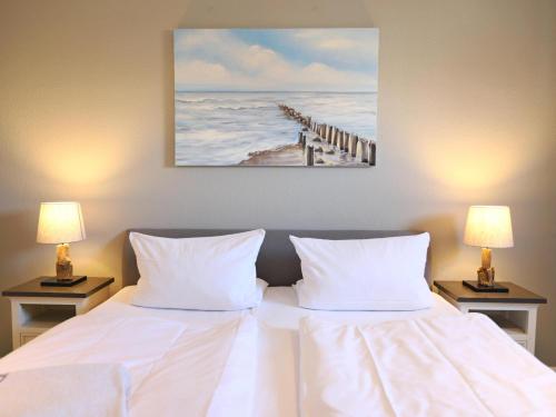 a bed with two white pillows and a painting on the wall at Andreas-Nielsen-Str. 12, W2 in Westerland (Sylt)