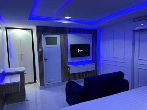 a room with a bed and a tv in it at Villa Palazzo Hotel 2 in Ikeja