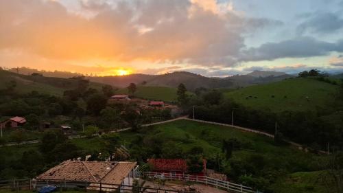 a sunset over a small village on a hill at Sítio Ramos casa azul in Cunha