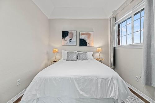 a white bedroom with a bed and a window at Urban Oasis in Plano 5BD & Heated Pool in Plano