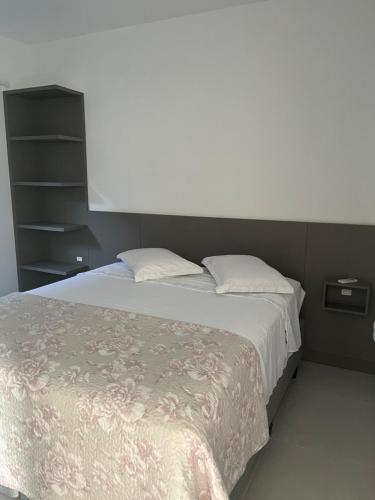 a bedroom with a large bed with white sheets at Eu Sou do Mar apto térreo 1 in Palhoça